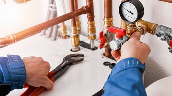 Klempnerkonzept oder Servicearbeiter. Kupferrohrleitungen in Nahaufnahme mit analogem Druckmesser | © Adobe Stock